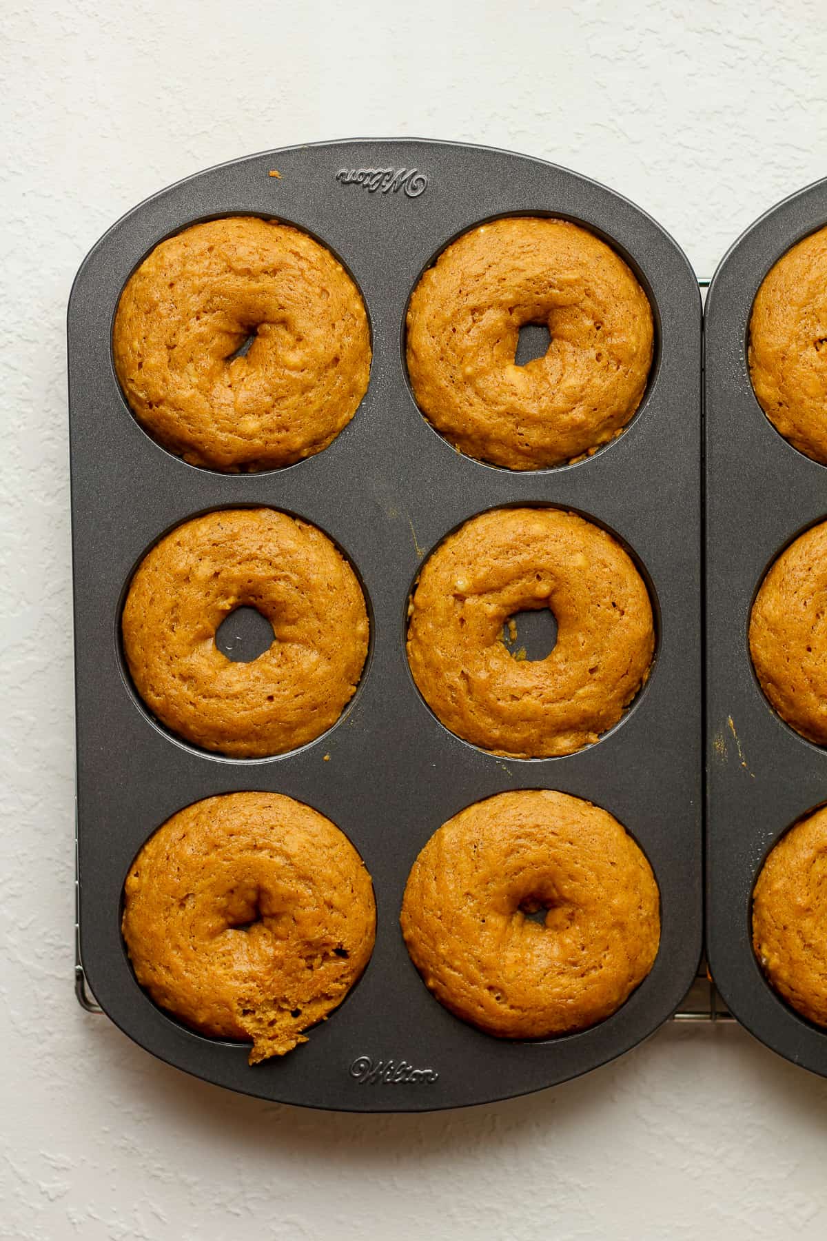 Donut pans with just baked pumpkin donuts.