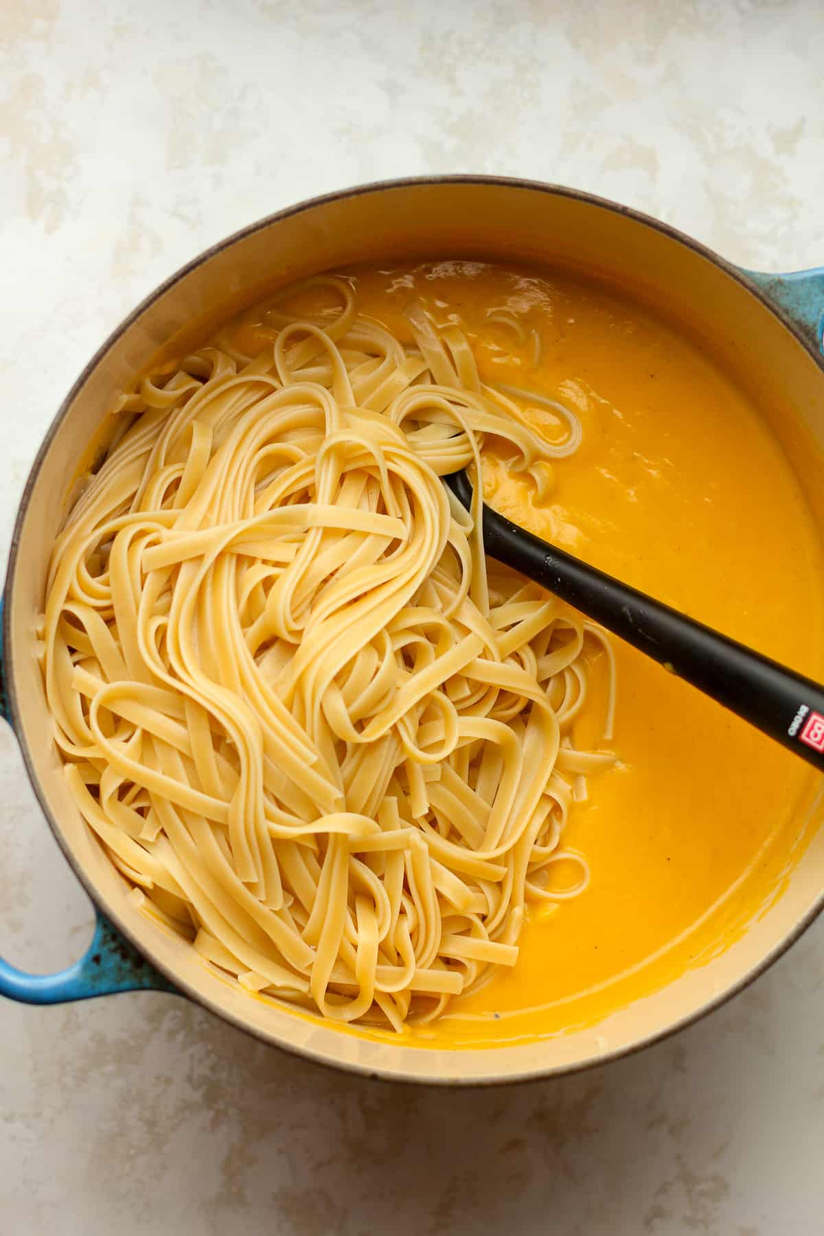 A stock pot of the butternut squash pasta sauce with fettuccine noodles.