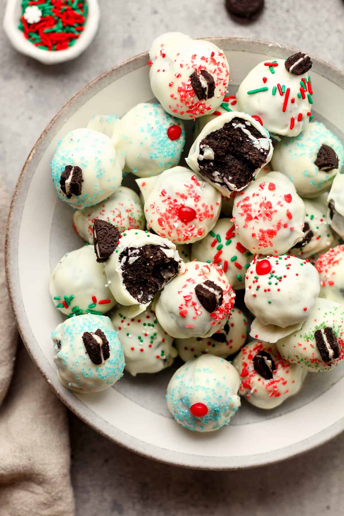A bowl of White Chocolate Oreo balls decorated with Christmas sprinkles.