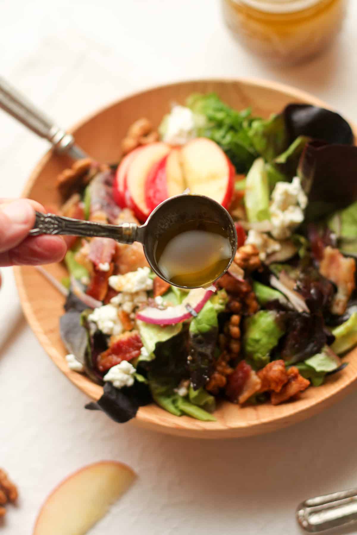 Overhead view of a spoonful of balsamic honey dressing over a serving of the harvest salad.