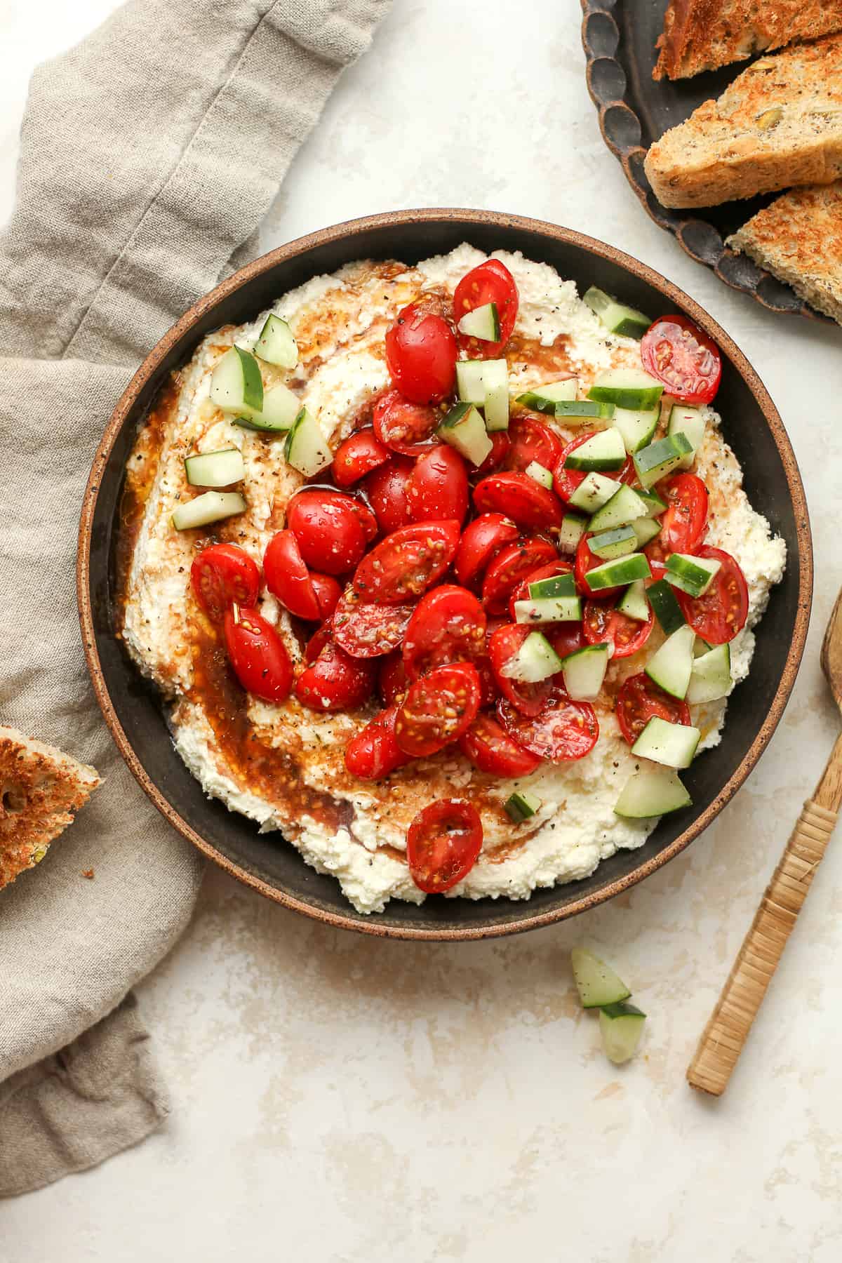 A bowl of the Greek whipped feta dip loaded with tomatoes.