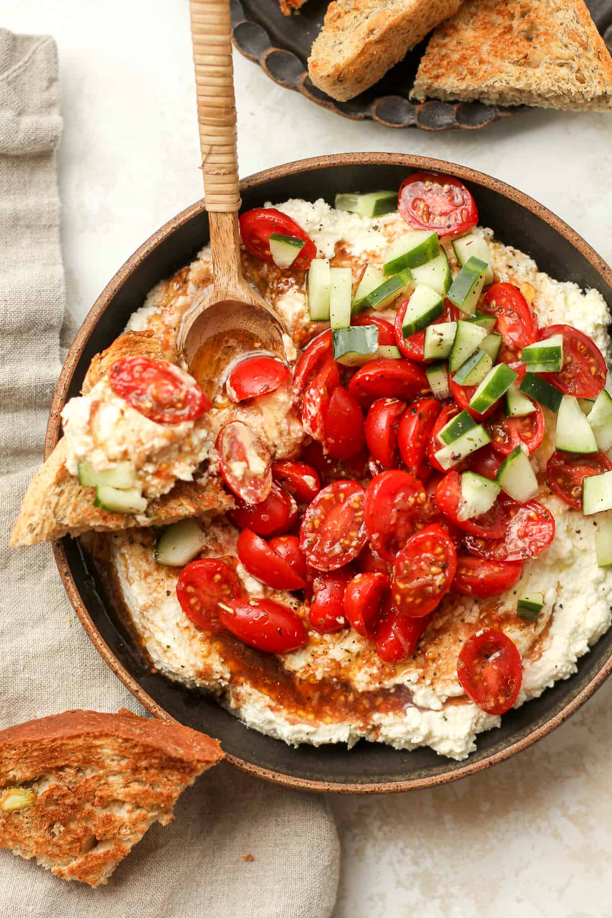 A bowl of the Greek feta dip with some piled on some toasty bread.