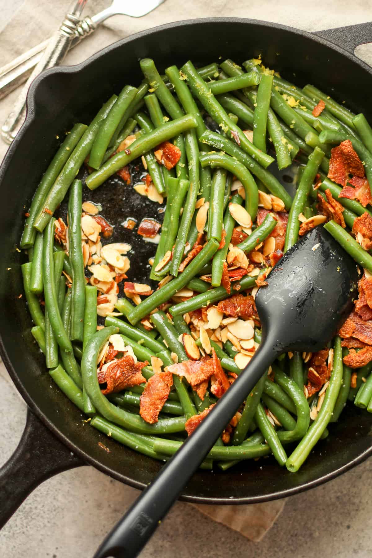 A skillet of the green beans, bacon, and sautéed almonds.