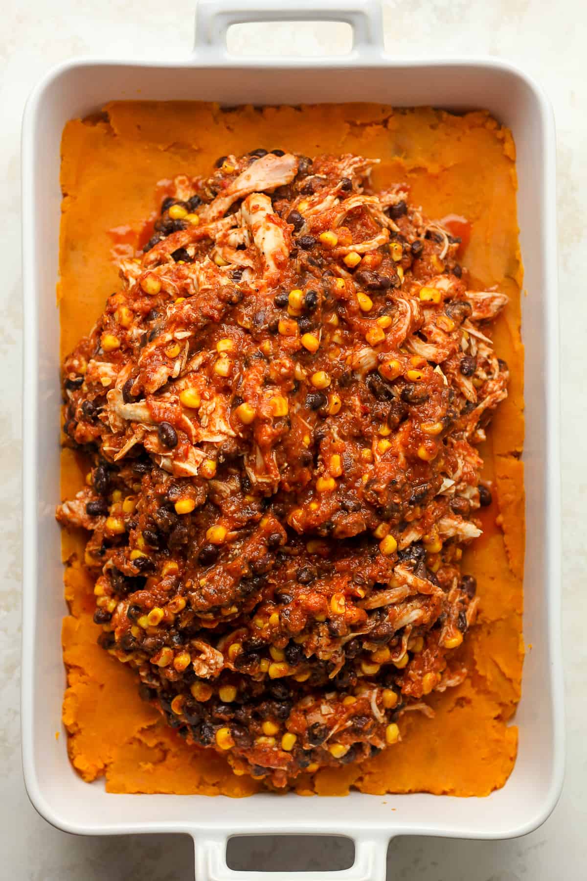 The casserole showing the sweet potato layer and the chicken with sauce on top.
