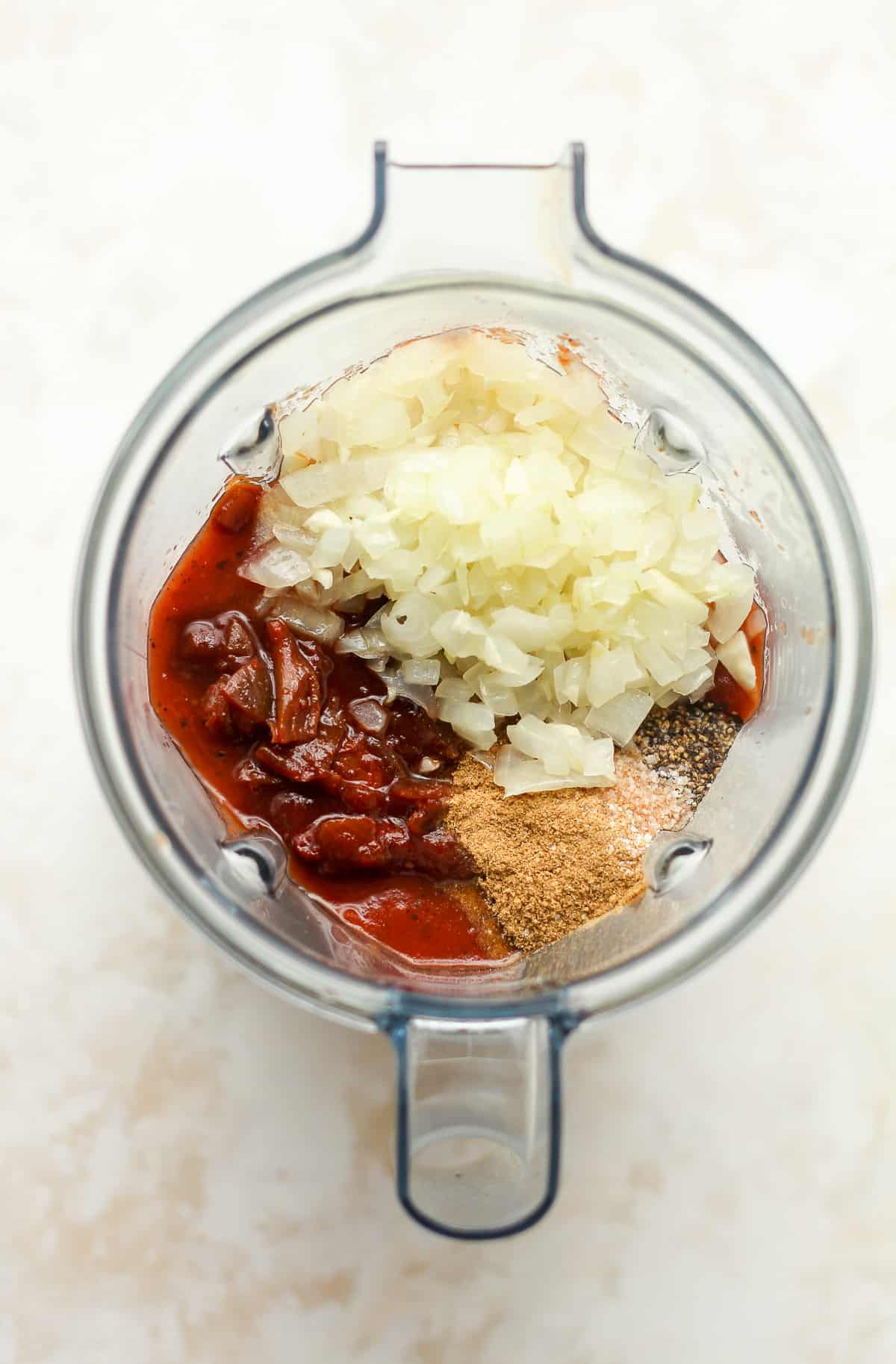 A blender of the sauce with the onions on top.