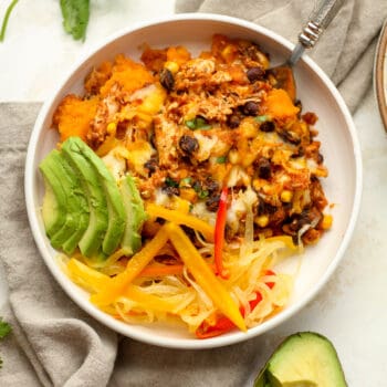 A bowl of Mexican chicken casserole with avocado slices.