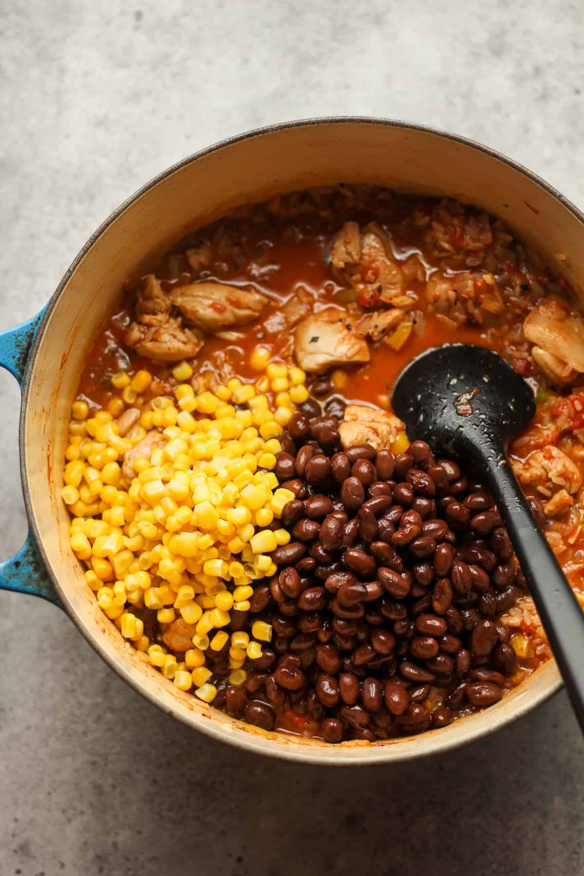 A pot of the chicken and rice with black beans and corn on top.