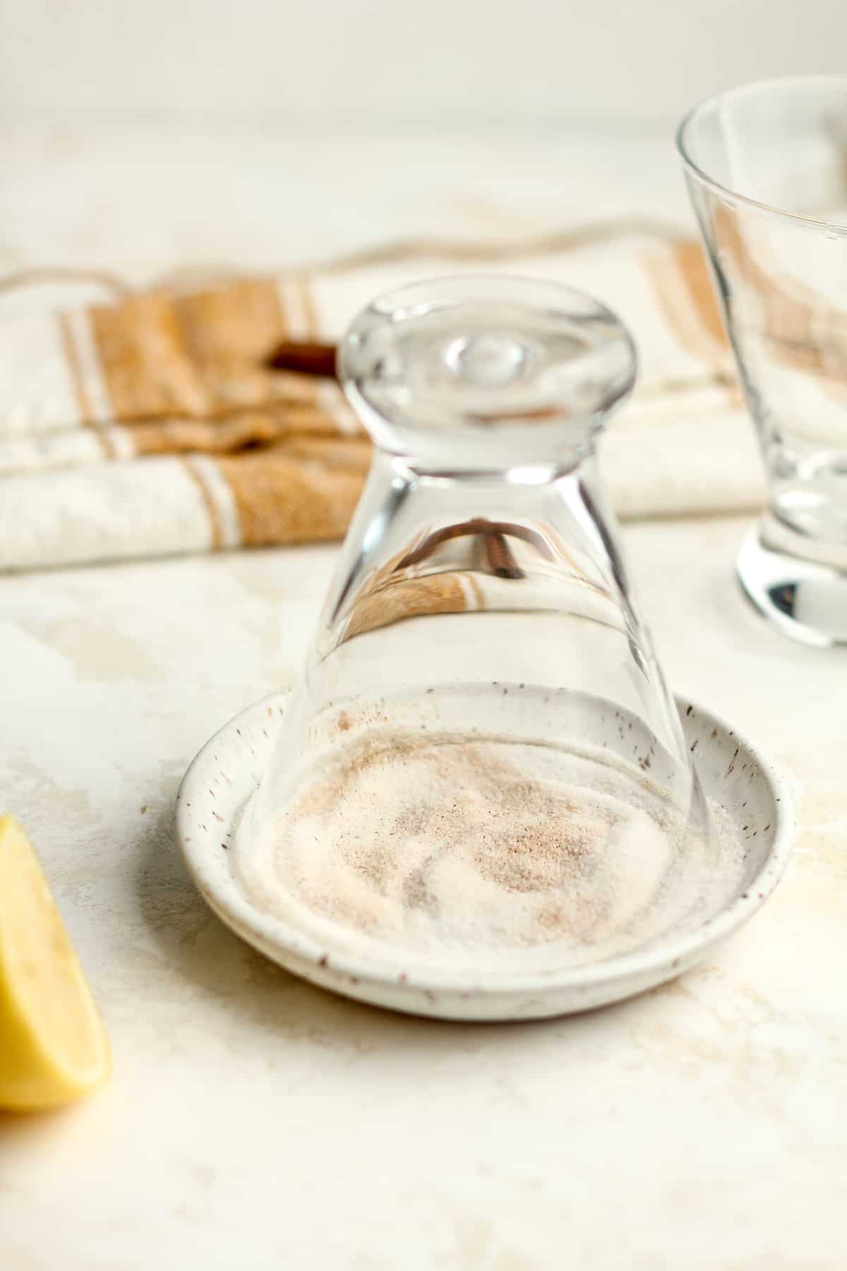 A glass turned upside down in a plate of cinnamon and sugar.