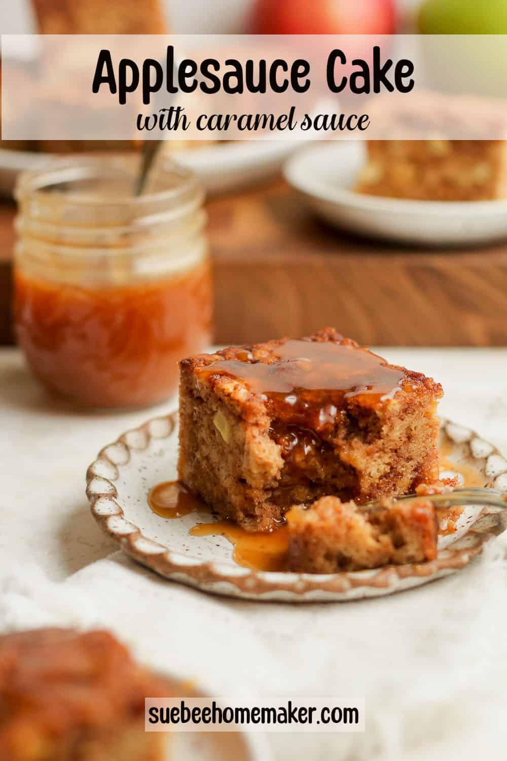 Side view of a piece of apple cake with caramel sauce, and a jar of caramel in the background.