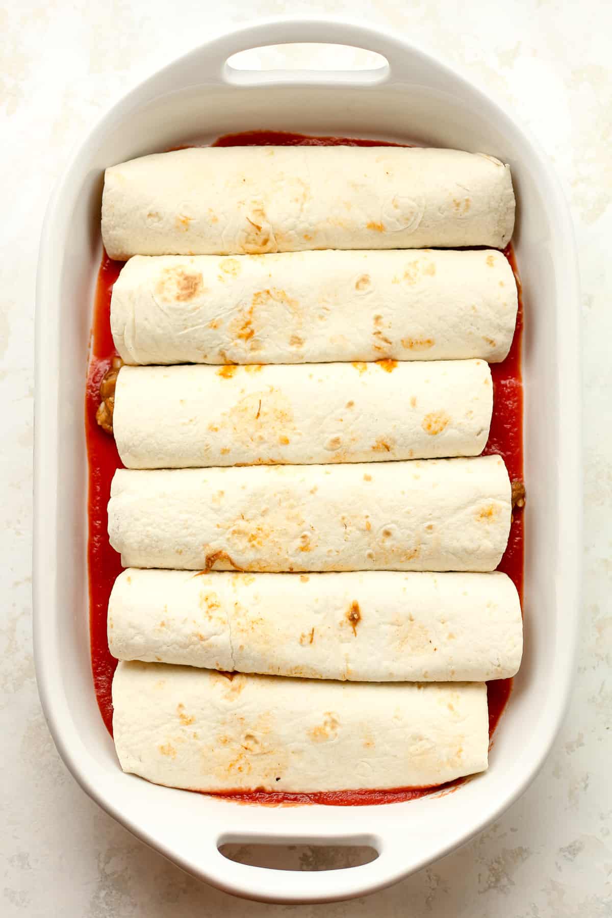 A casserole of the beef enchiladas before adding the sauce and cheese on top.