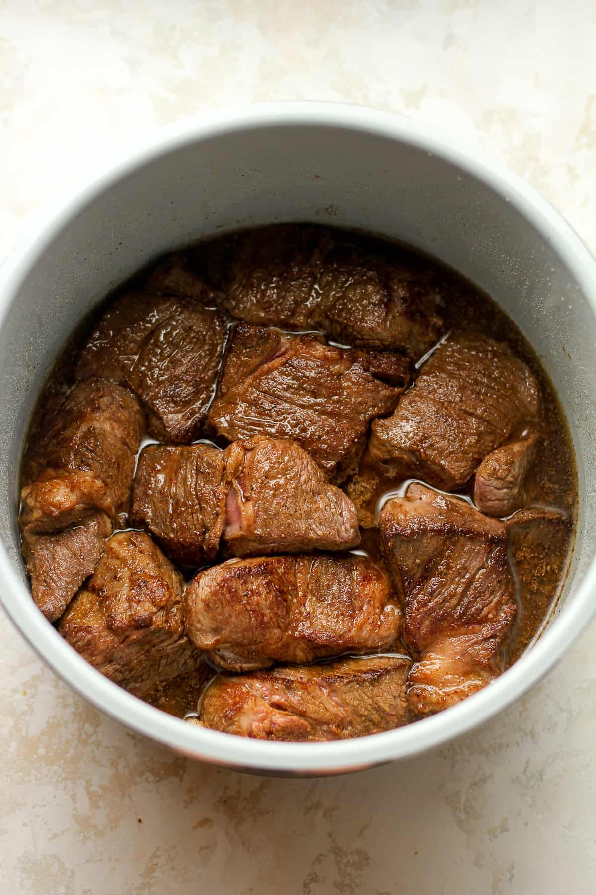 An instant pot bowl of browned chuck roast.