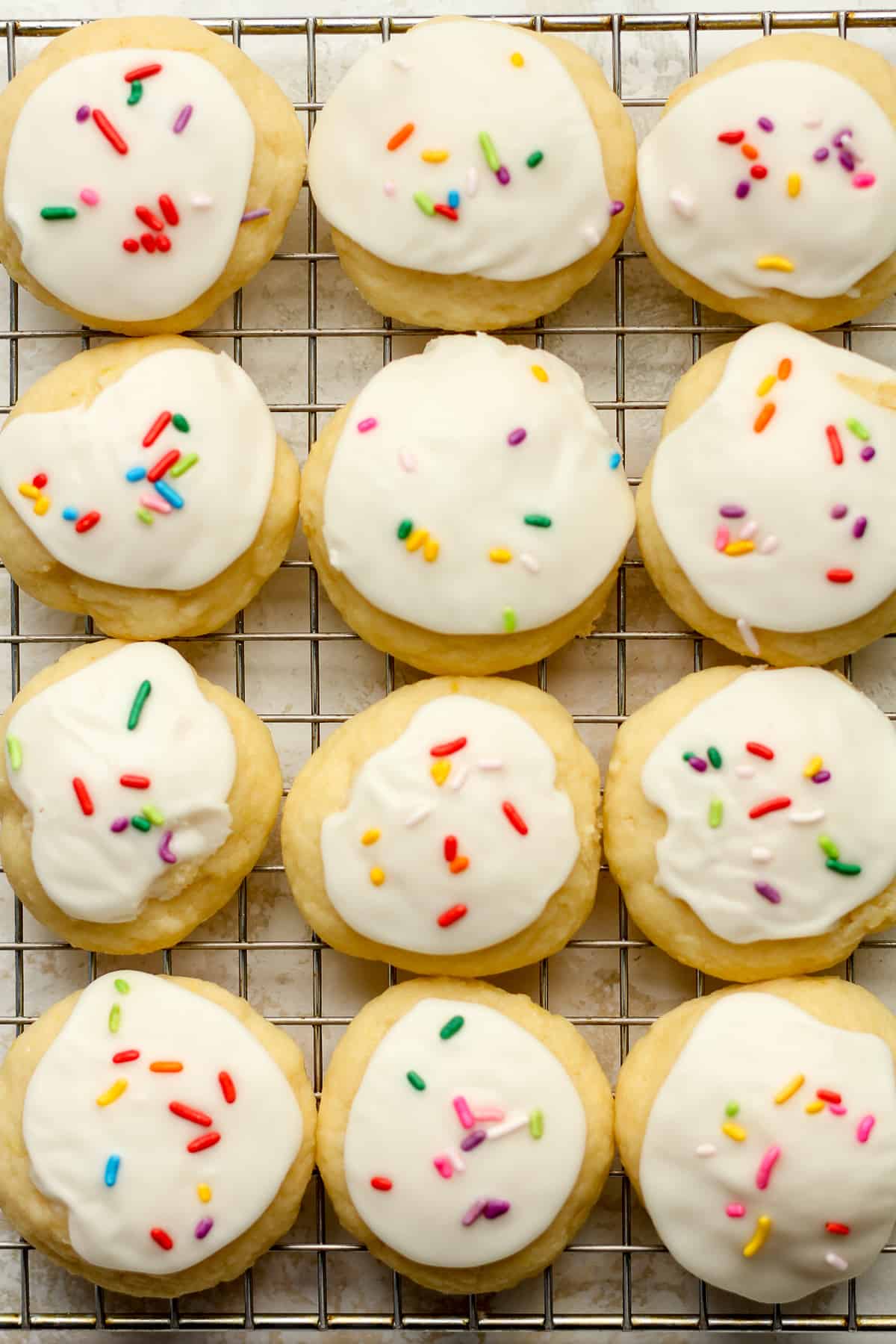 A wire rack with Italian ricotta cookies with lemon.