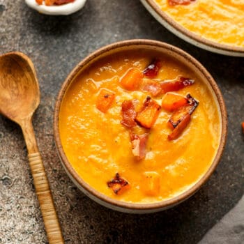 A small bowl of butternut squash soup with bacon.