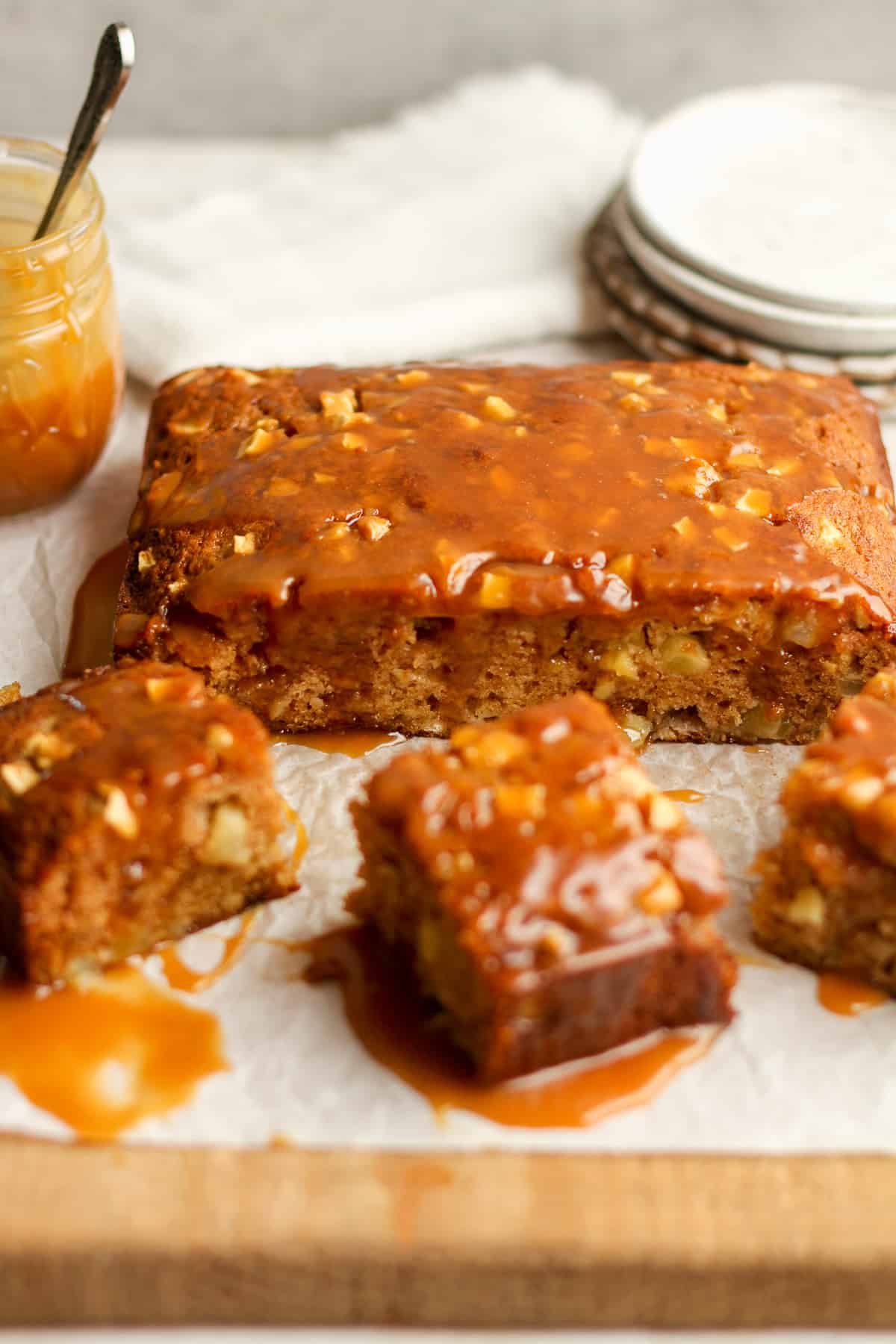 Side view of a apple cake with some pieces with caramel sauce.
