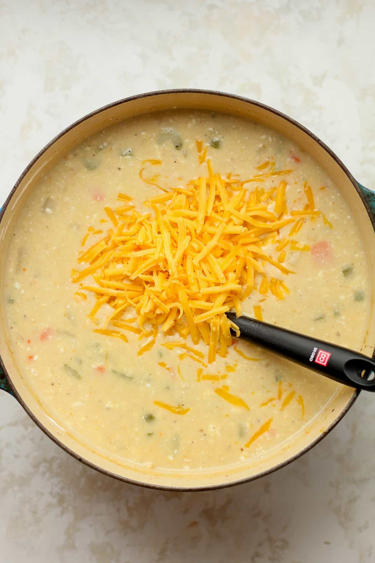 The pot of soup with the cheese on top.