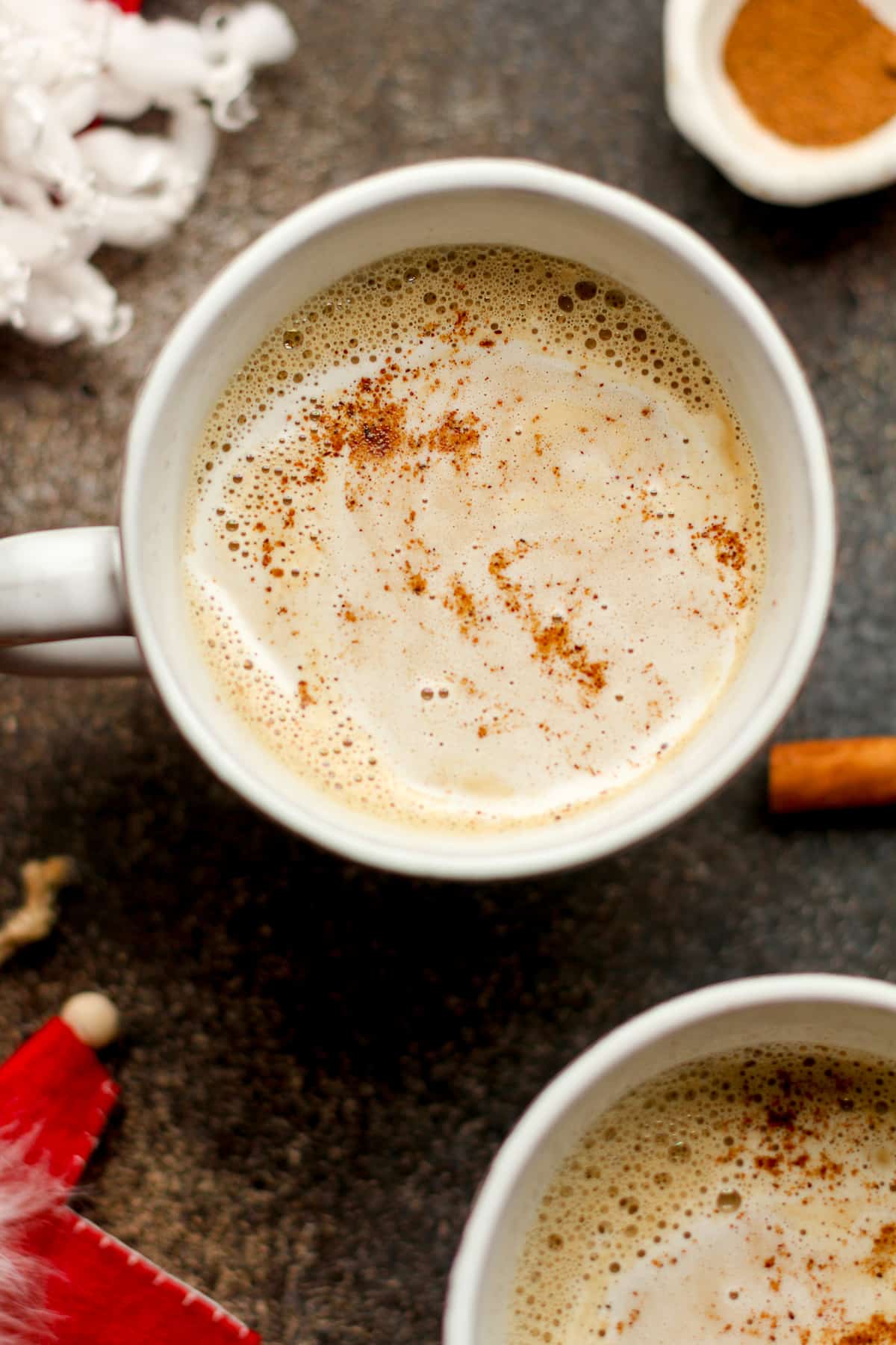 Overhead view of eggnog lattes with cinnamon sticks.