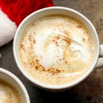 Closeup on an eggnog latte with cool whip on top.