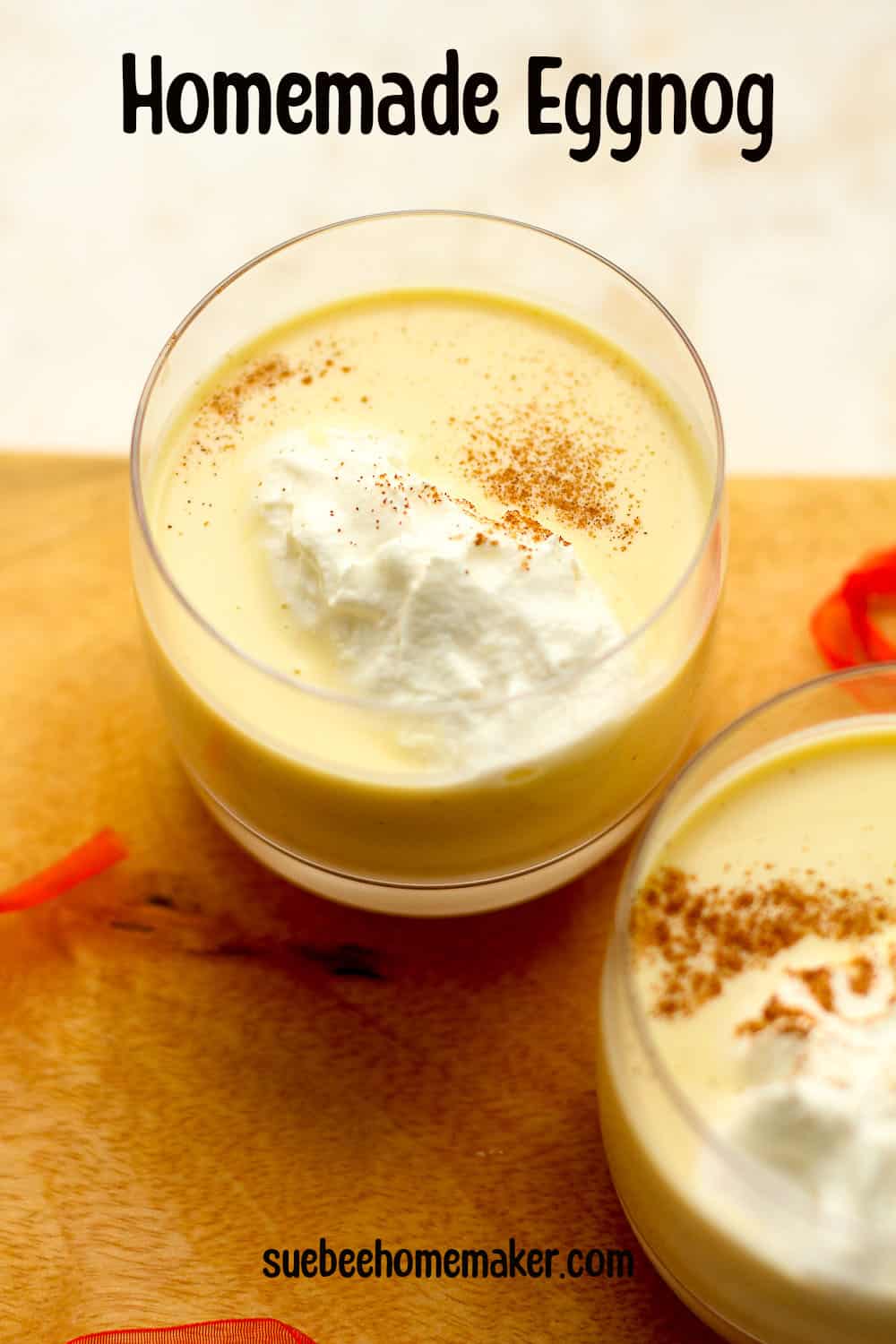 Two glasses of creamy homemade eggnog with whipped cream.