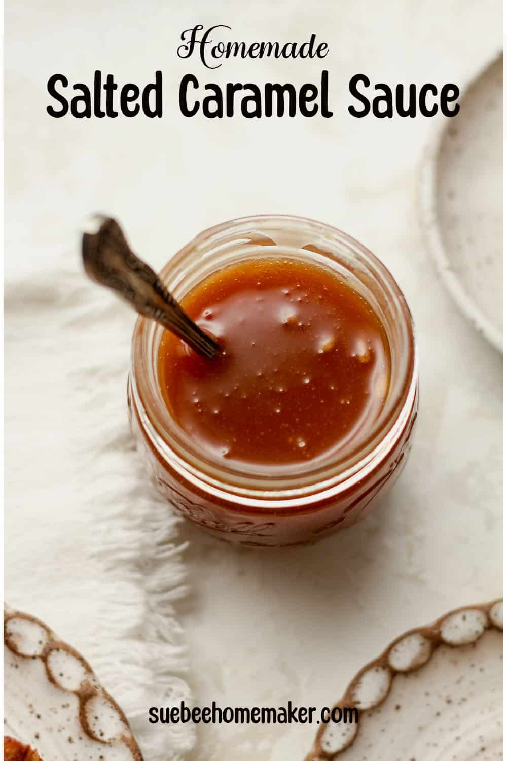 A jar of homemade caramel sauce with a spoon.