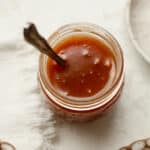 A jar of salted caramel sauce with a spoon.
