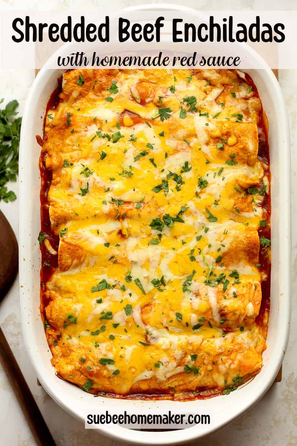 A casserole of shredded beef enchiladas with homemade red sauce.