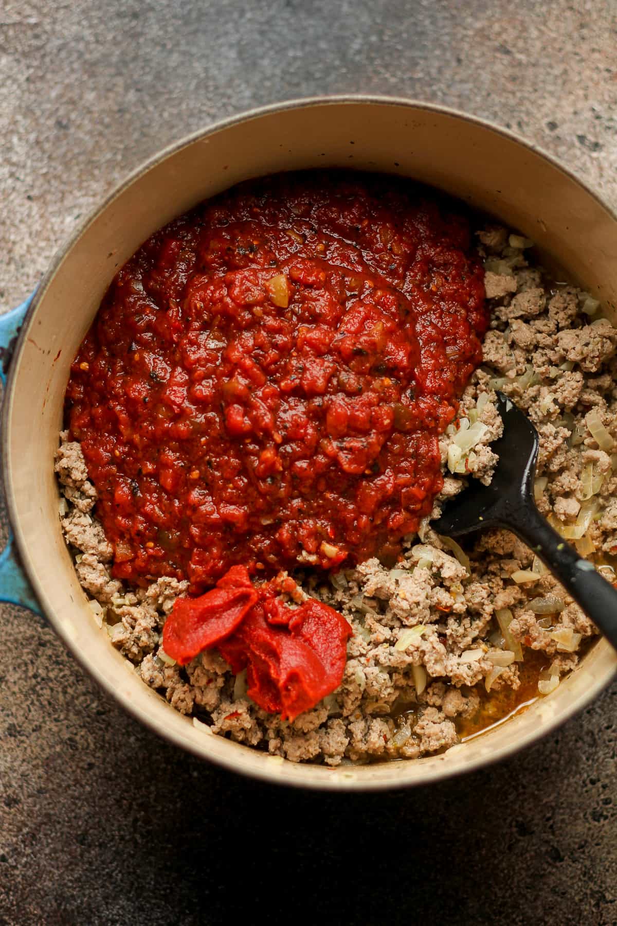 A pot of the ground beef with tomatoes on top.