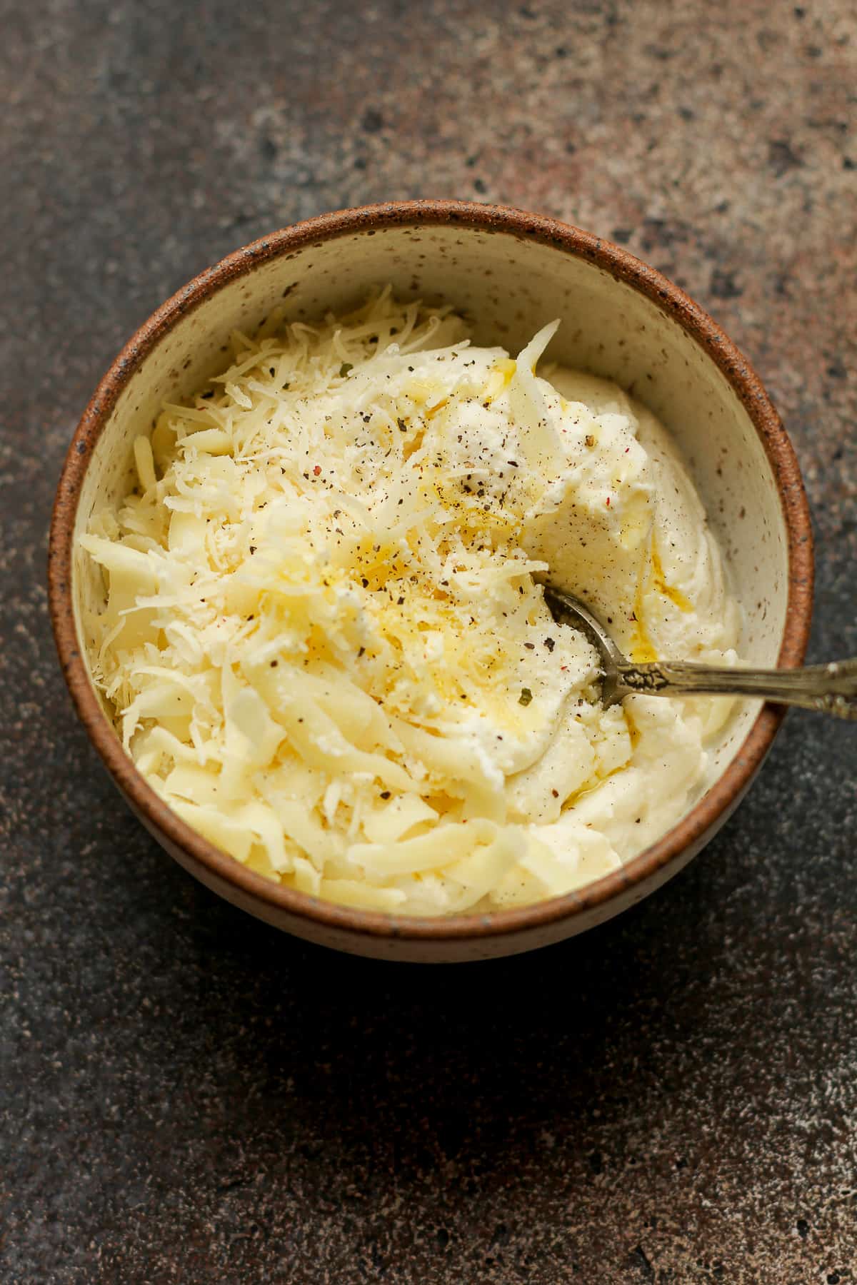 Overhead shot of a bowl of a combo of three types of cheese.