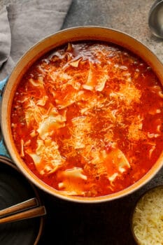 Overhead shot of a pot of lasagna soup with a gray napkin.