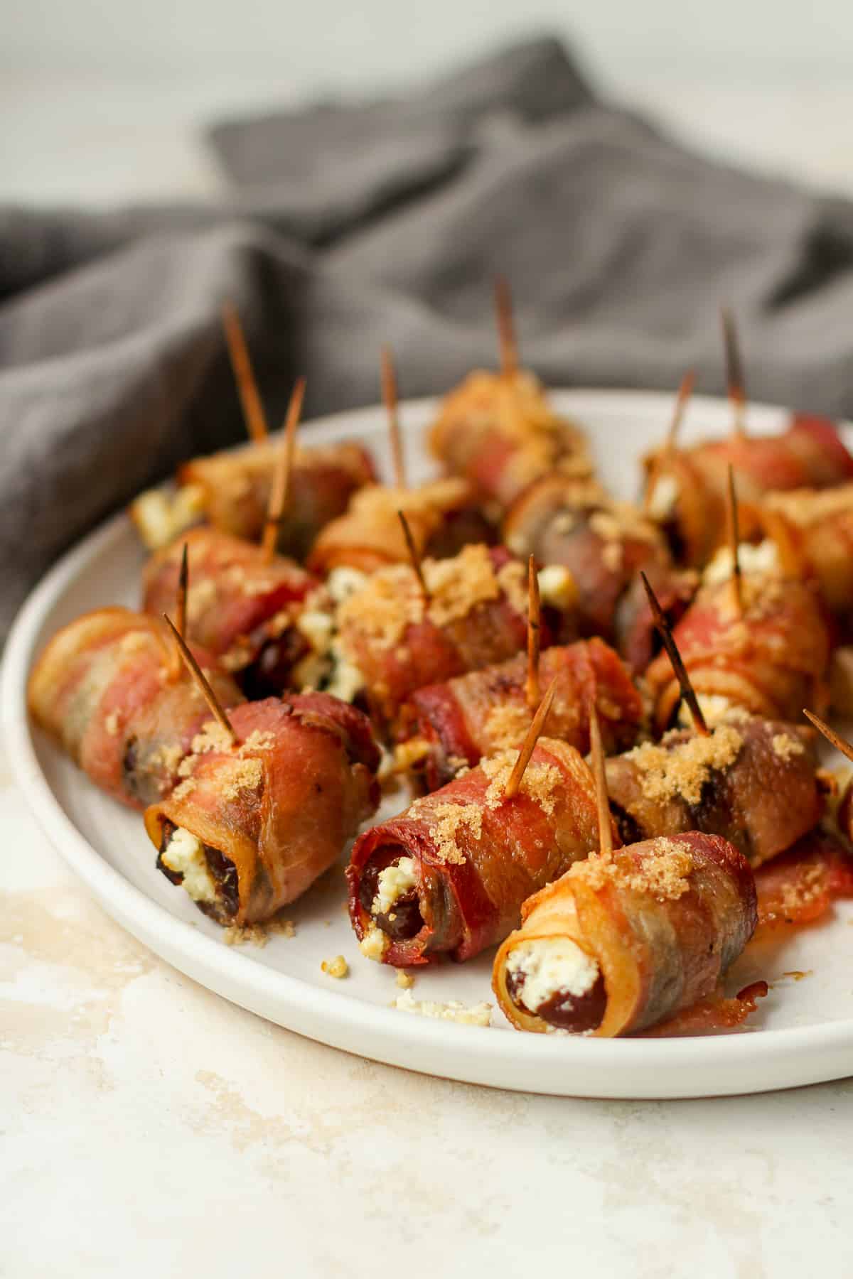 Side view of some bacon wrapped dates with goat cheese.