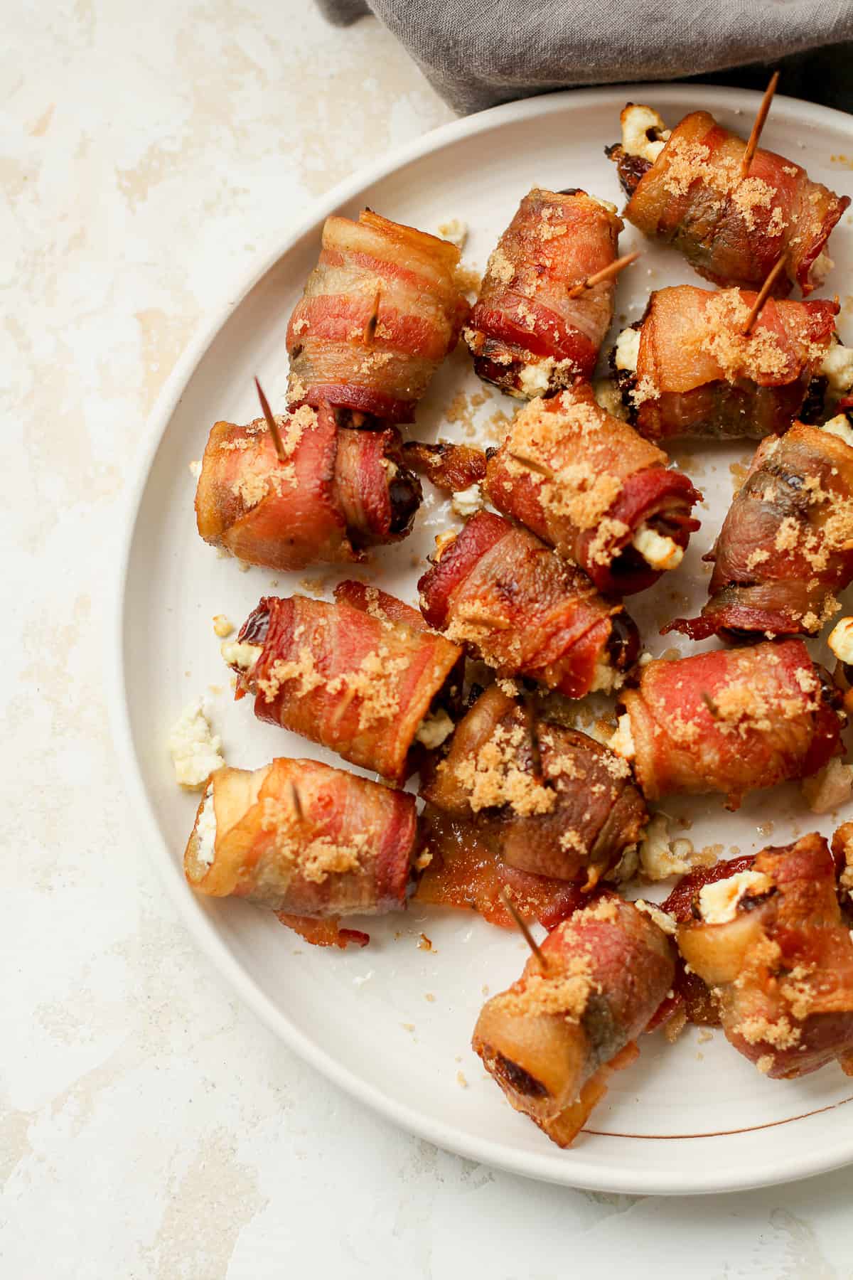 A partial plate of bacon wrapped goat cheese dates.