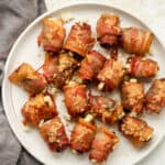 A plate of bacon wrapped dates with goat cheese.