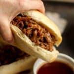 My hand dipping a beef sandwich into au jus.