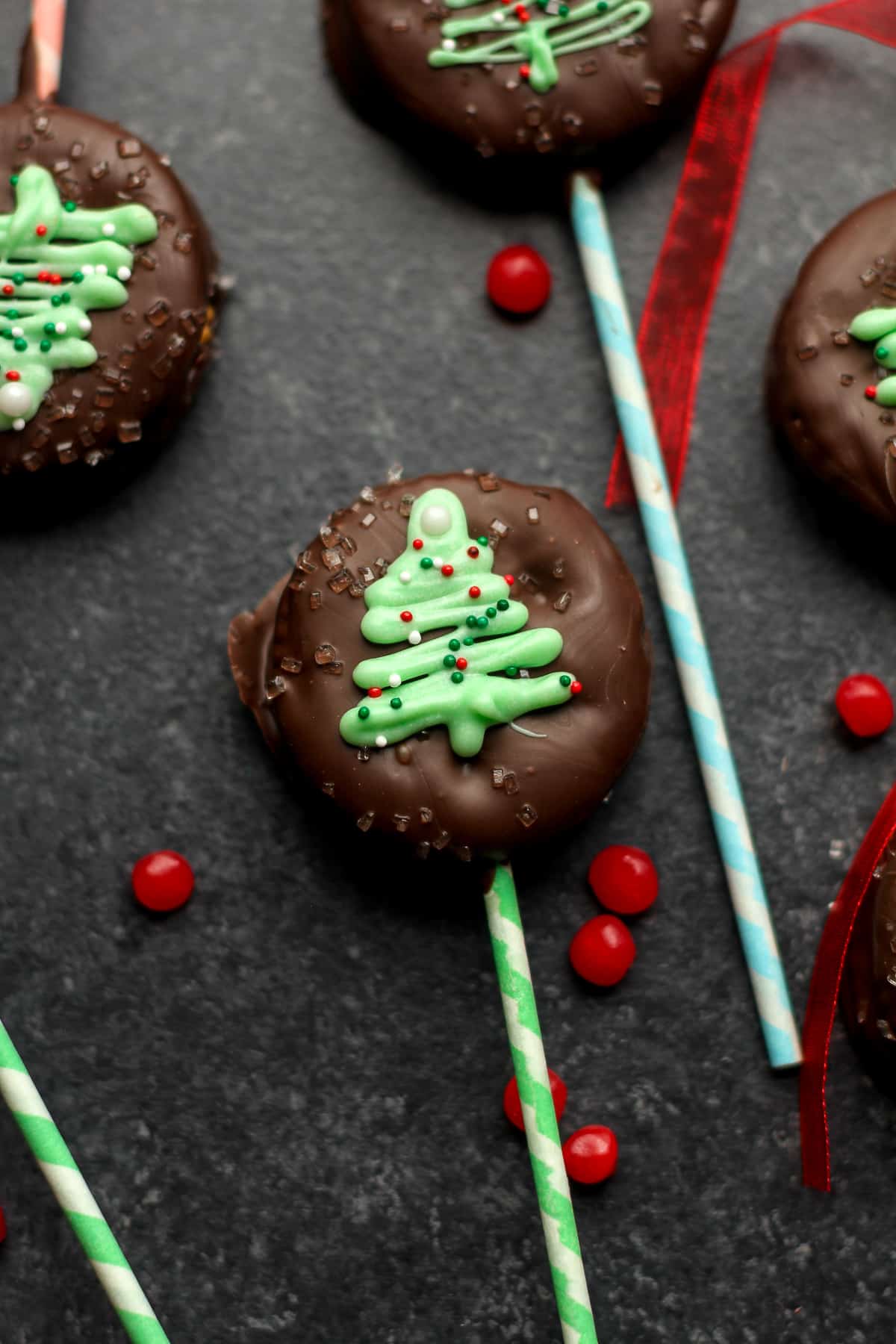 A dark background with some Christmas tree ritz cracker pops.
