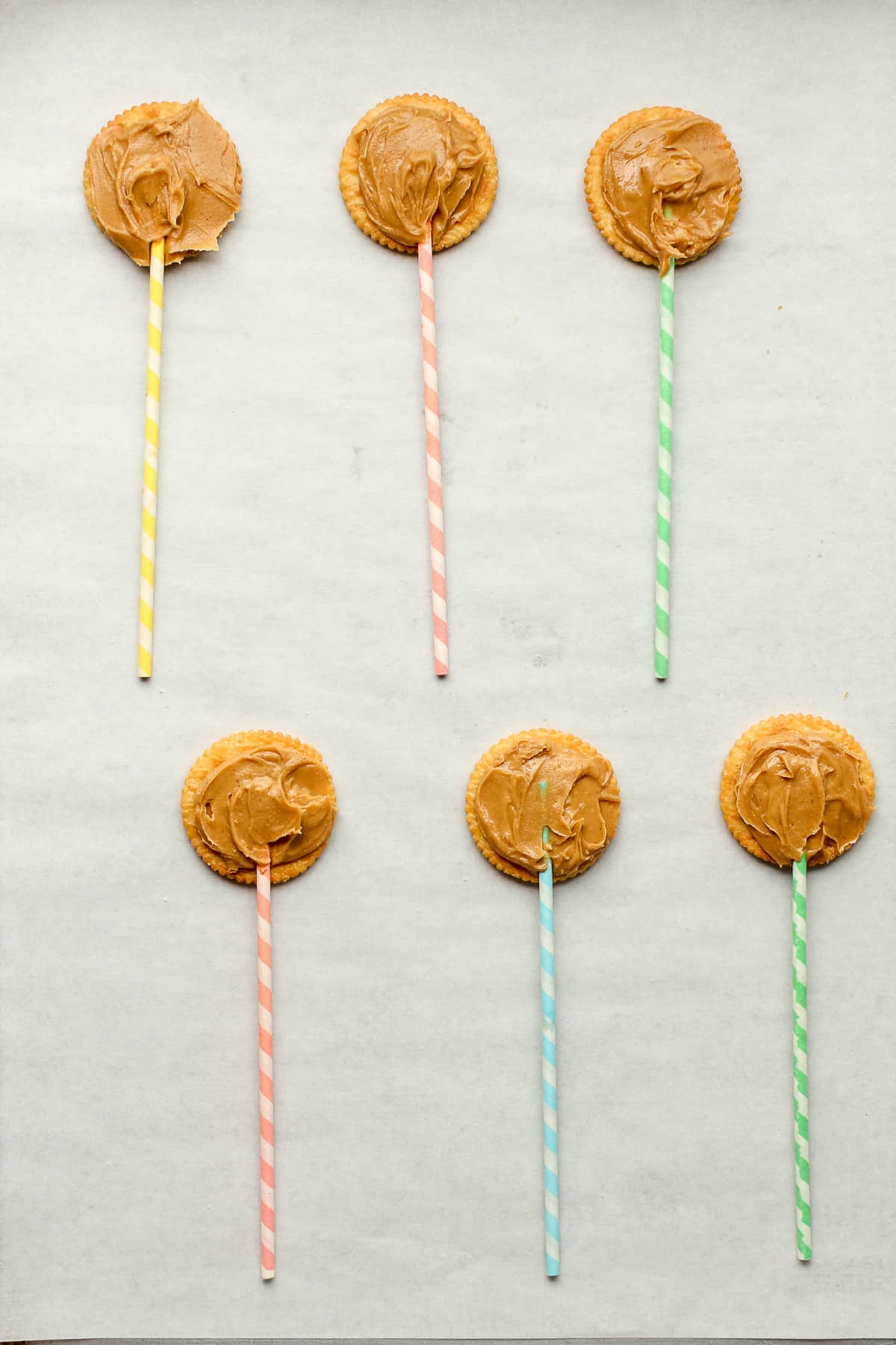 The ritz crackers with peanut butter and a lollipop stick on top.