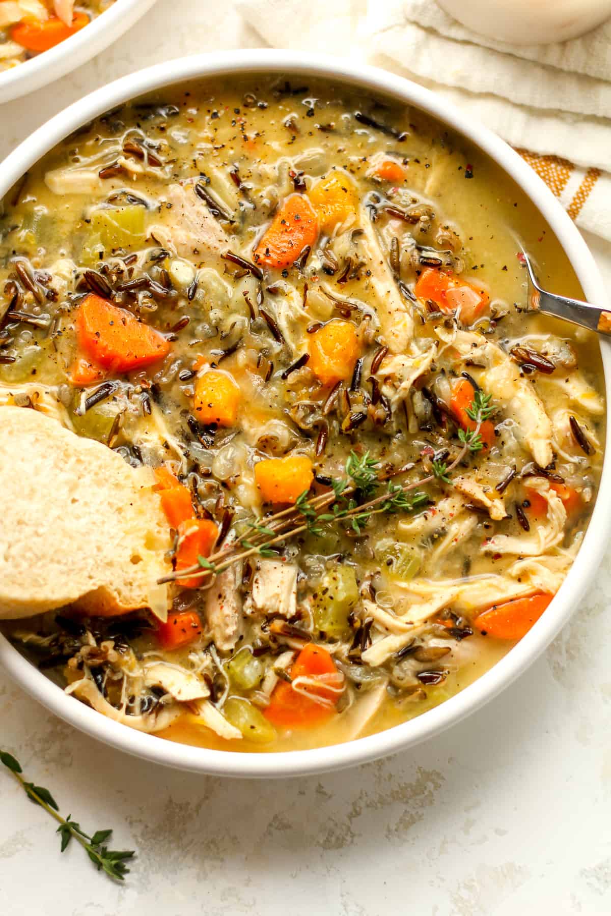 Closeup shot of a bowl of creamy wild rice soup with turkey and butternut squash.