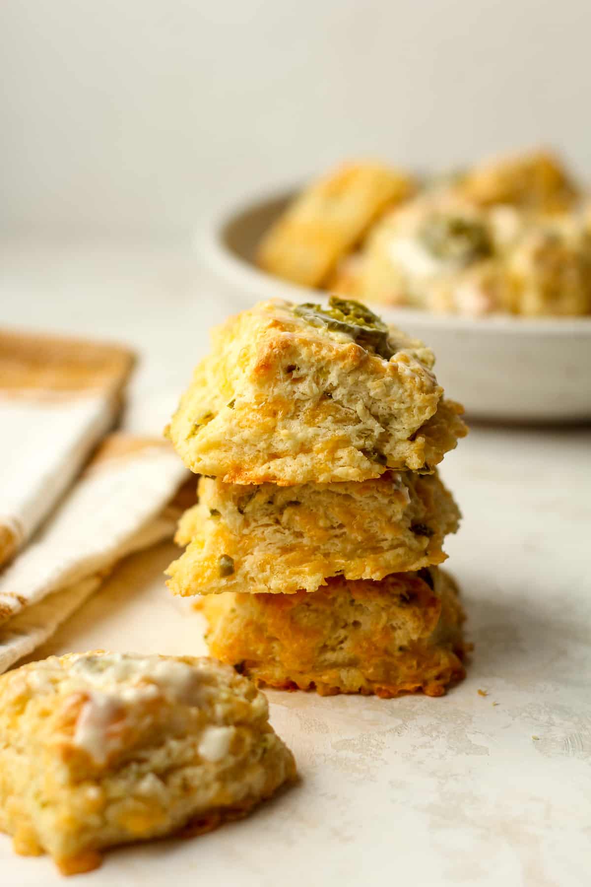 Three stacked jalapeño cheddar biscuits with a napkin.