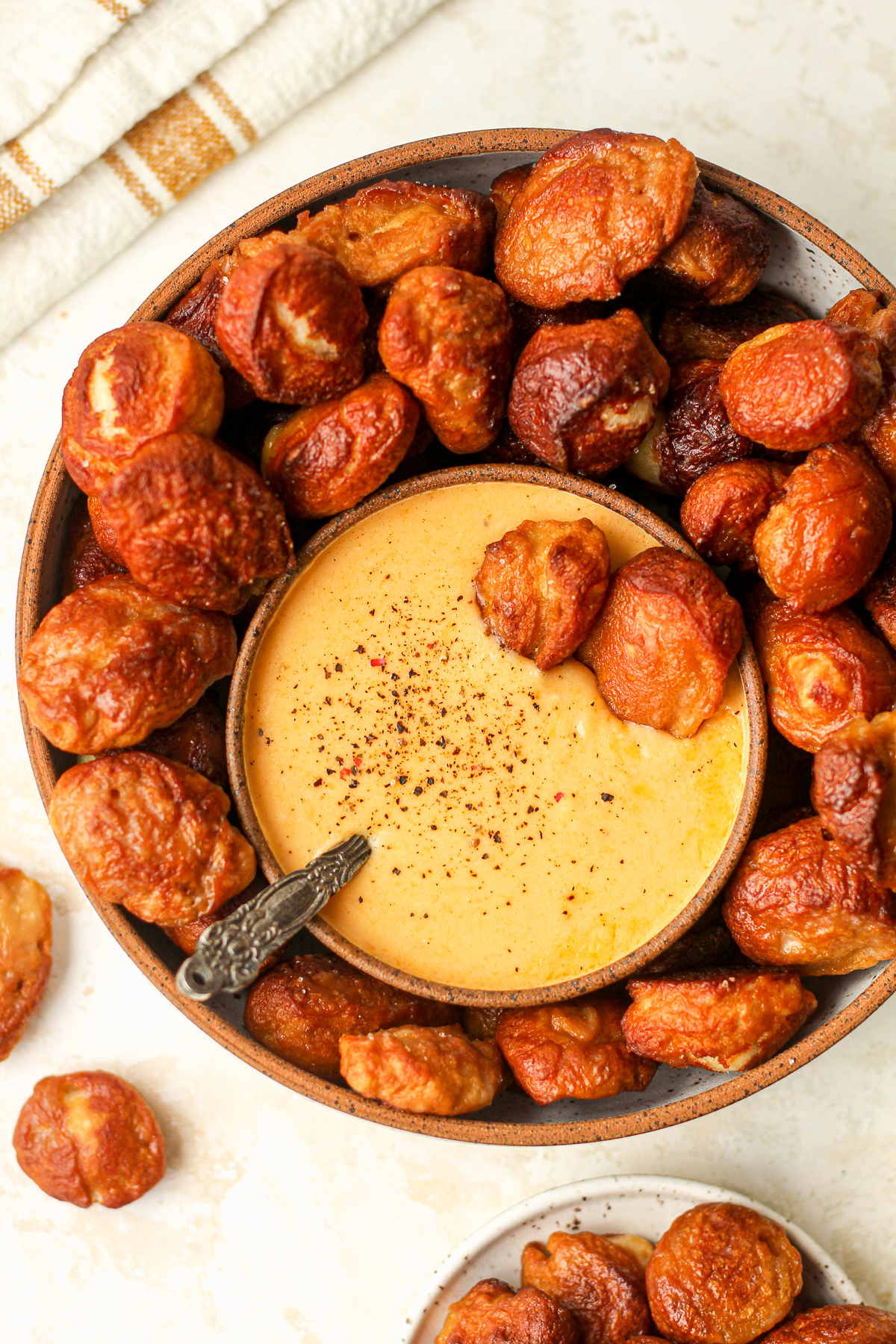 A bowl of the homemade pretzel bites with some cheese dip.