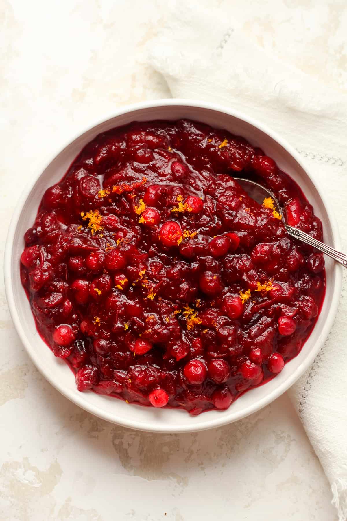 Overhead view of a bowl of cranberry sauce with orange zest.