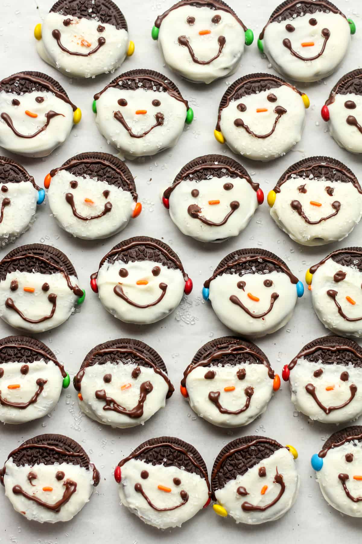A tray of snowman Oreo cookies with earmuffs.