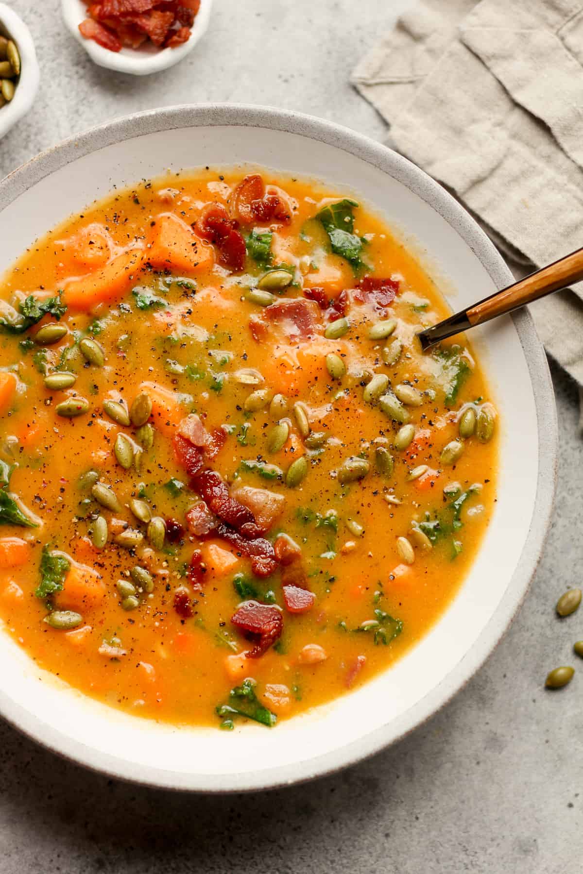 A bowl of sweet potato chowder with bacon.