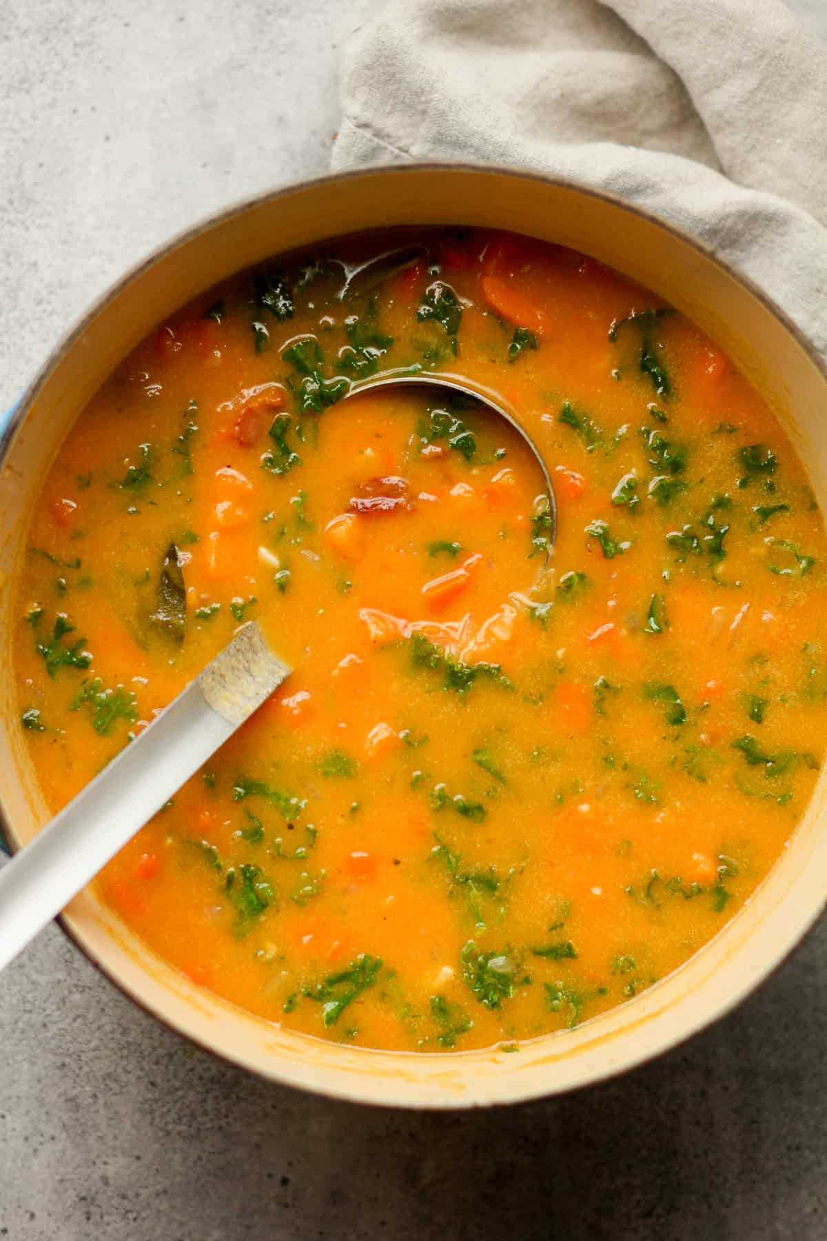 Overhead view of a pot of sweet potato soup with kale.
