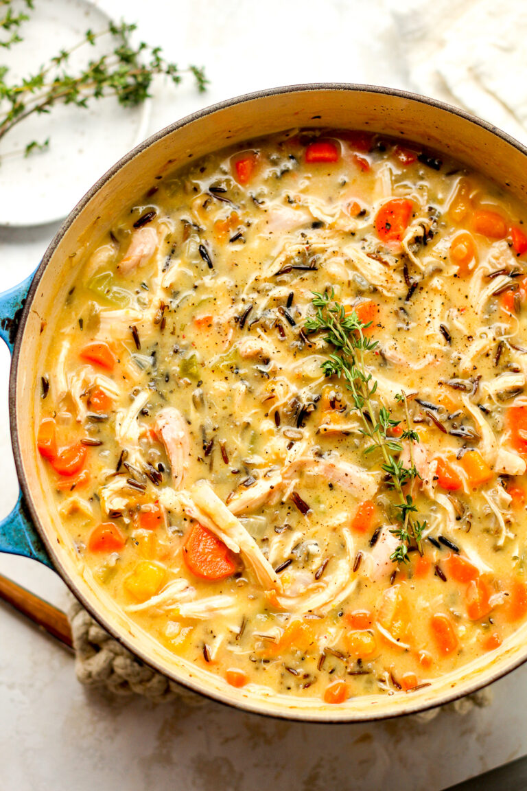 A stock pot of turkey wild rice soup with thyme.