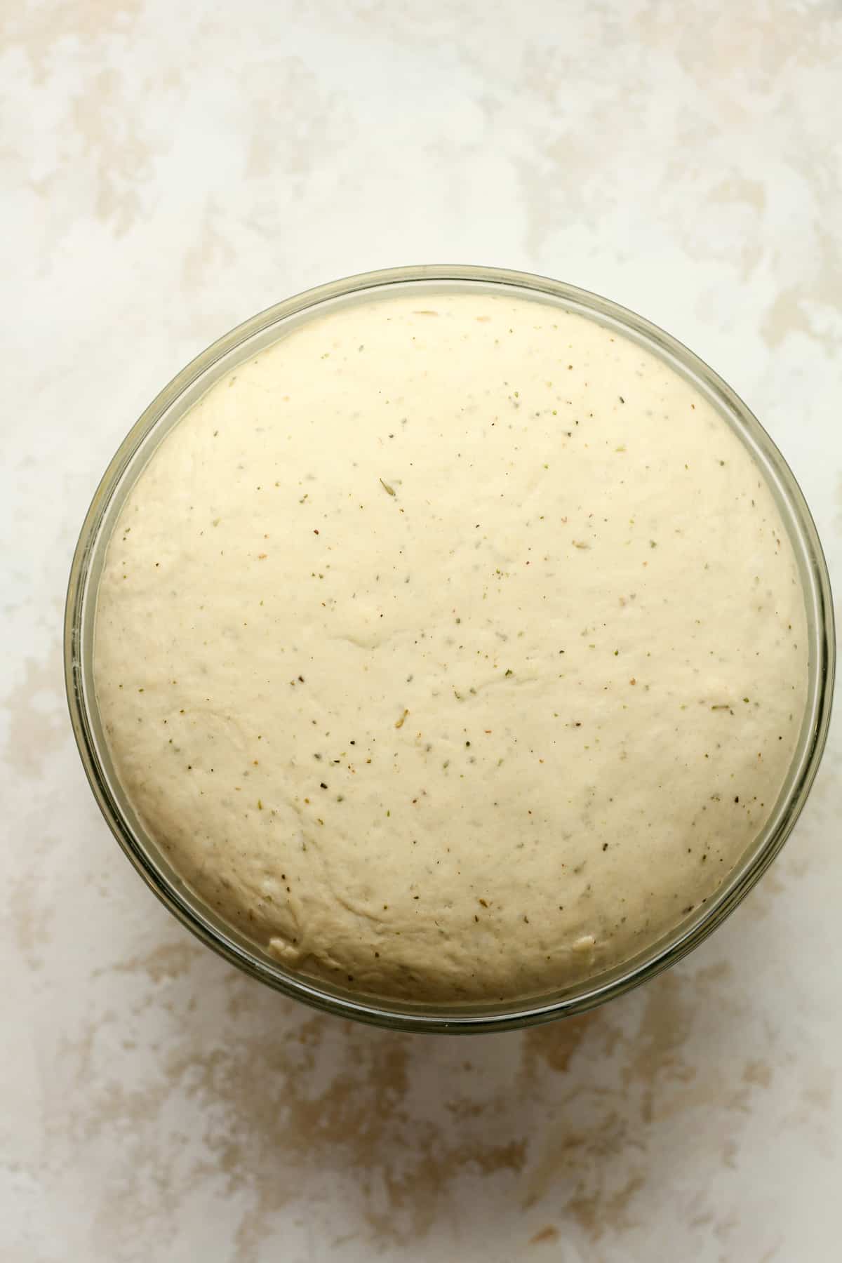 Overhead view of a bowl of raised dough.