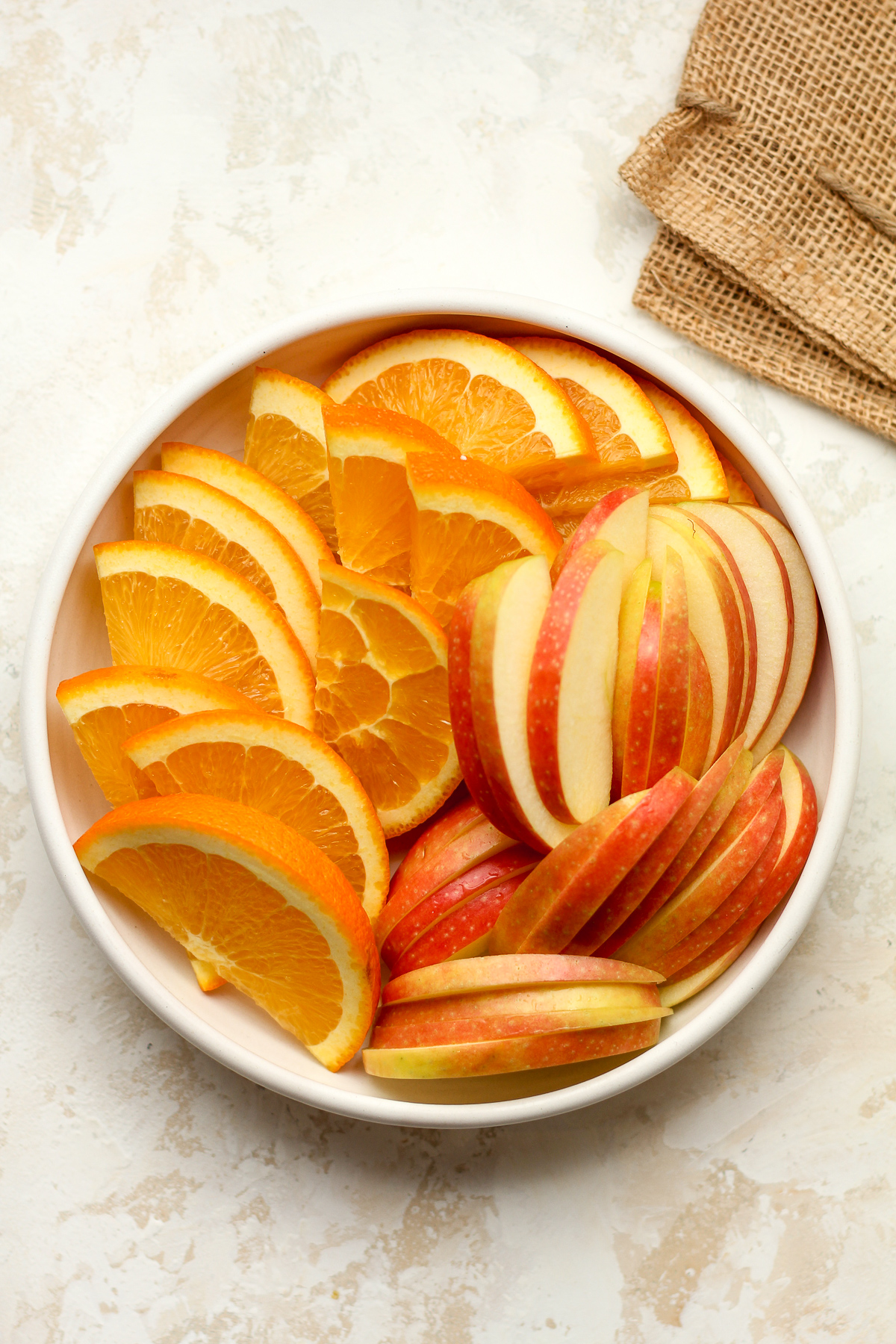 A plate of sliced oranges and apples.