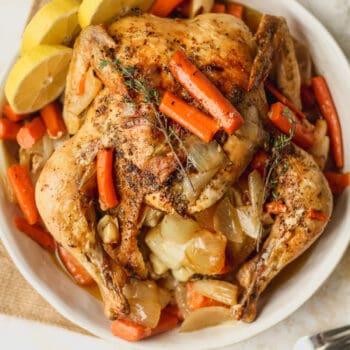 A round dish with a baked lemon garlic chicken with carrots.