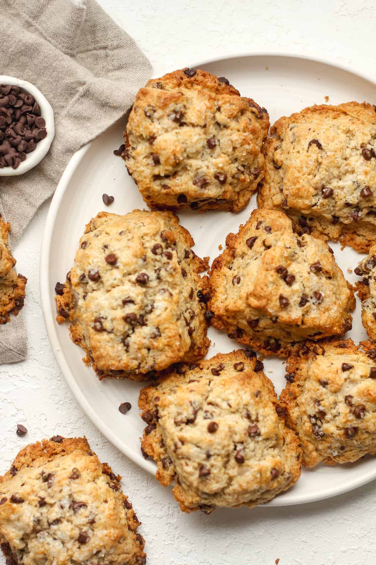 A plate of chocolate chip scones with a gray napkin.