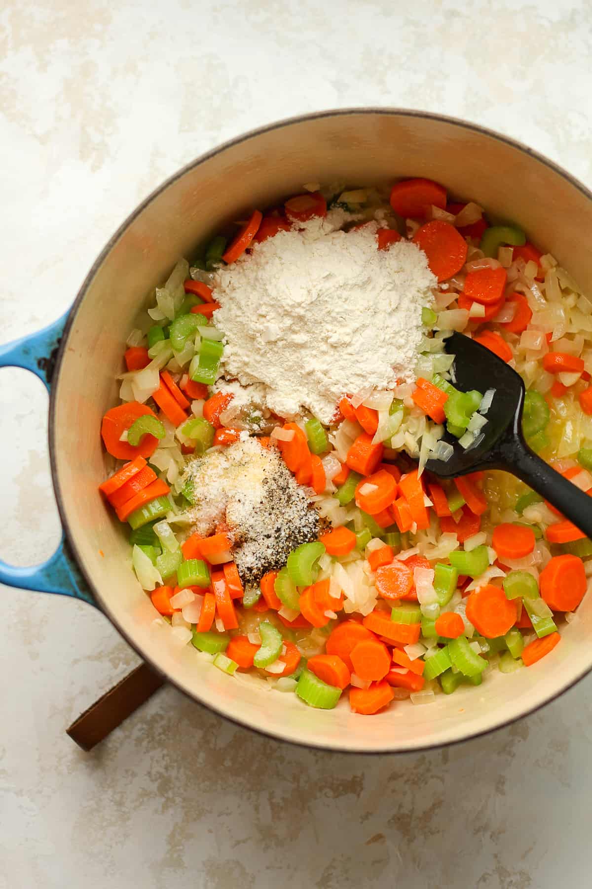 A pot of chopped veggies with the seasonings and flour on top.