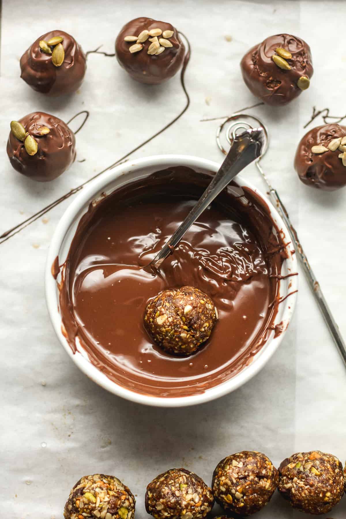 A sheet pan with a bowl of chocolate with date nut ball inside.