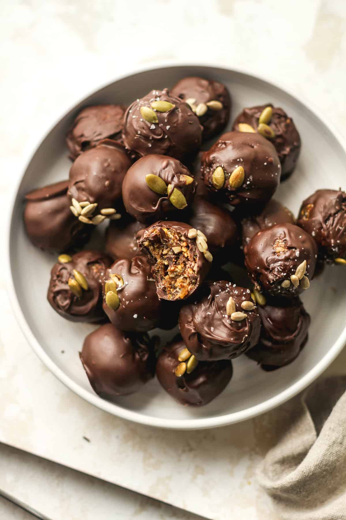 A bowl of date nut balls covered in chocolate.