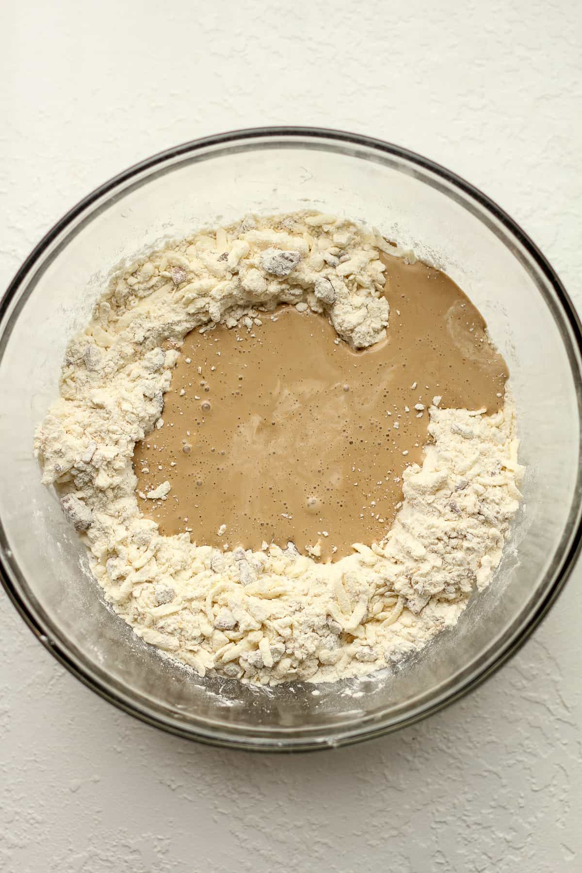 A bowl of the dry scone ingredients with the wet ingredients on top.